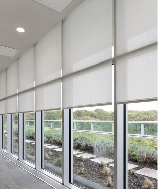 Estores enrollables en muro cortina con cortinero