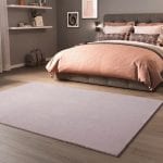 Alfombra rosa lisa de pelo en dormitorio